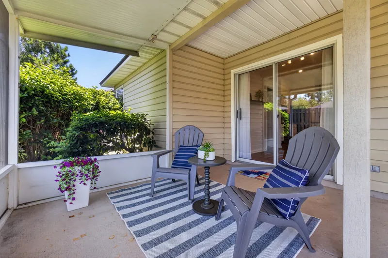 Covered back porch with chairs and planters