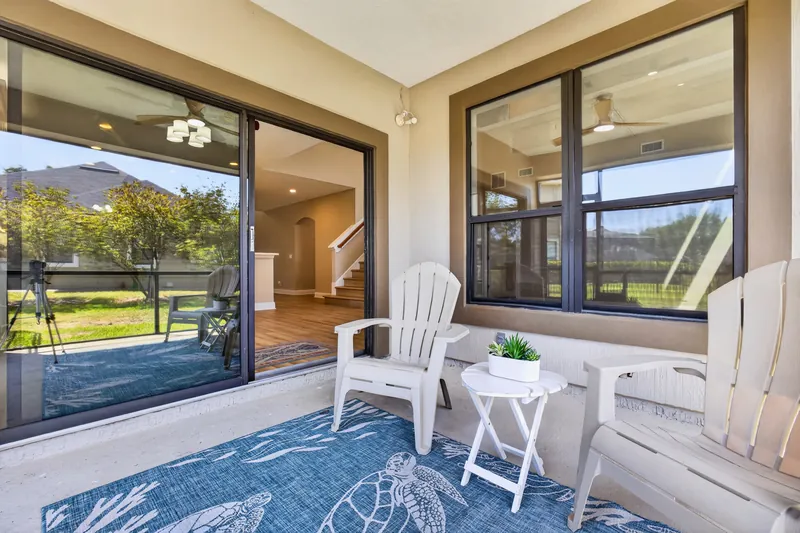 Screened lanai with seating and backyard view