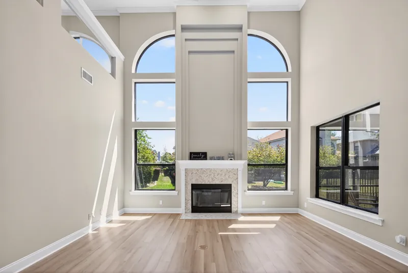 Two-story living room with arched windows and fireplace